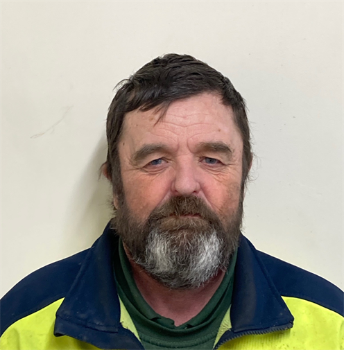 Photograph of a man with short, dark hair wearing a high visibility jacket. He has a dark beard. Photograph of a man with short, dark hair wearing a high visibility jacket. He has a dark beard.