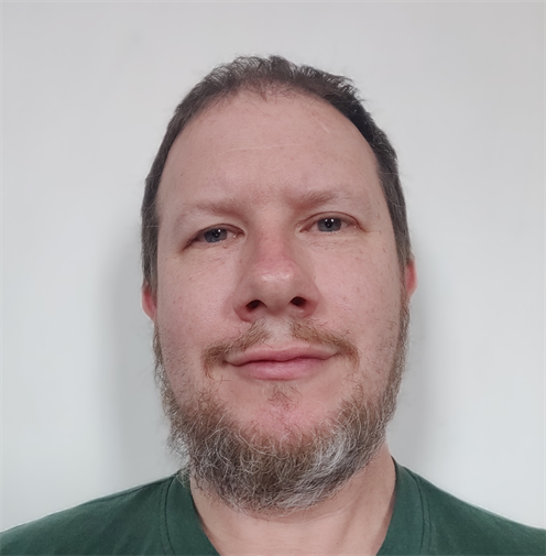Photograph of a man with a short beard and short hair. He is smiling. Photograph of a man with a short beard and short hair. He is smiling.