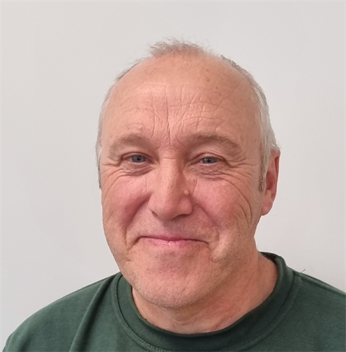 Photograph of a man with short blonde hair wearing a dark green work jumper. He is smiling nicely. Photograph of a man with short blonde hair wearing a dark green work jumper. He is smiling nicely.